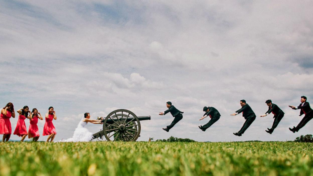 Staged photo of bride shooting groom with canon
