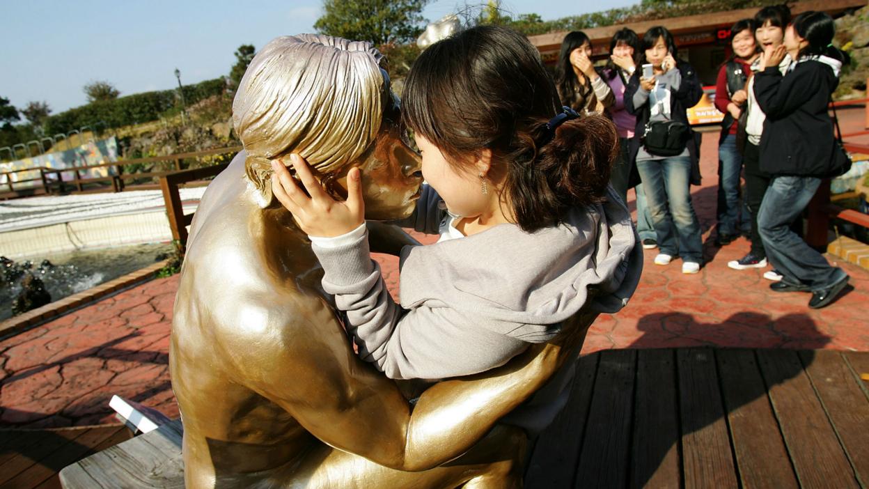 Girl kissing statue