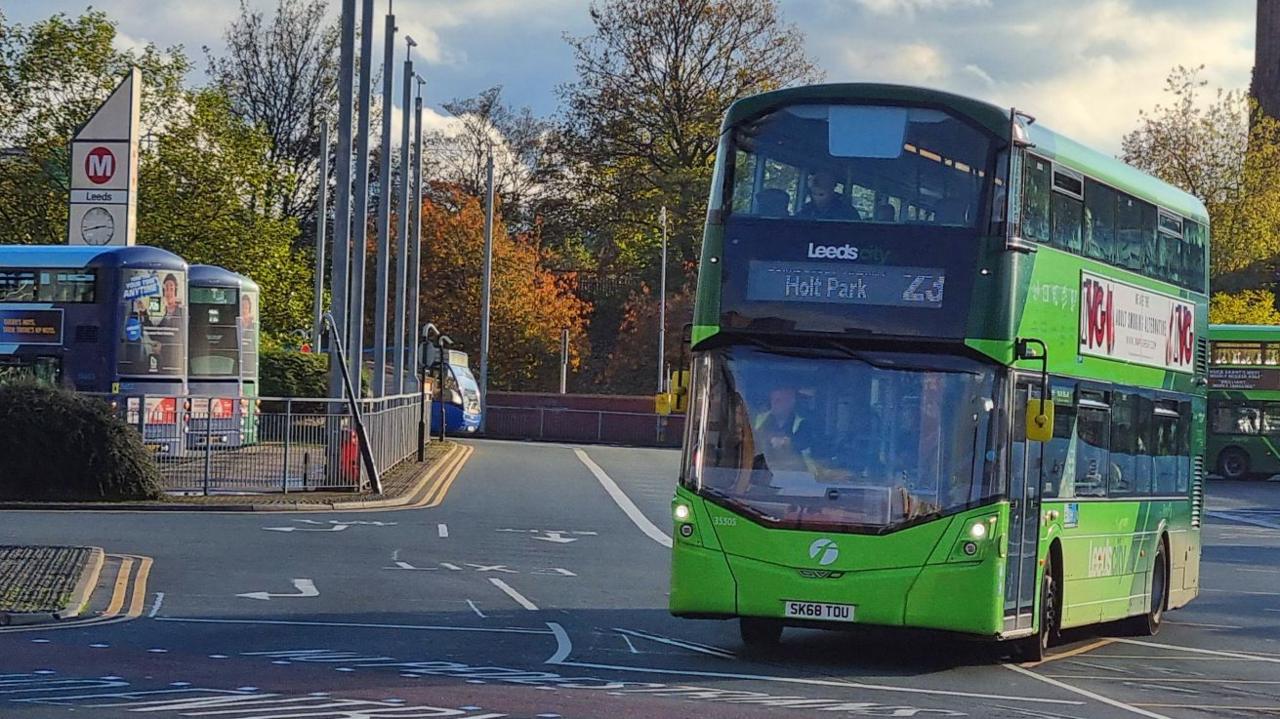 A green First-branded double-decker bus leaves Leeds Bus Station heading for Holt Park. 