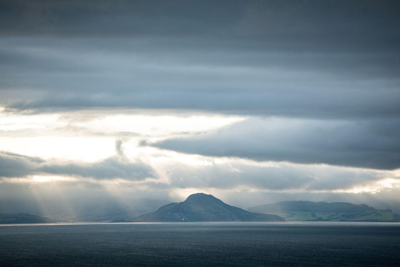 Swirling clouds with sun breaking through over the Isle of Arran, seen from Ayrshire

