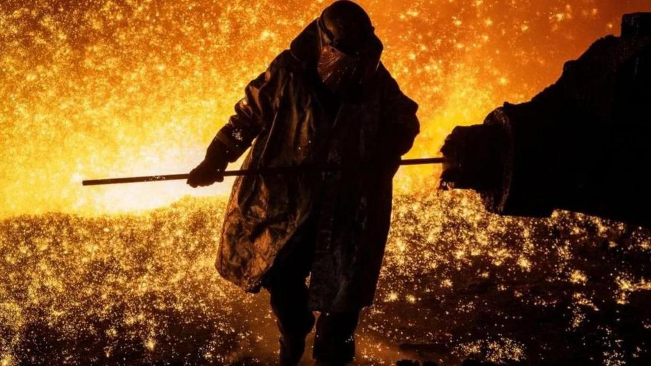 A steelworker tapping the blast furnace