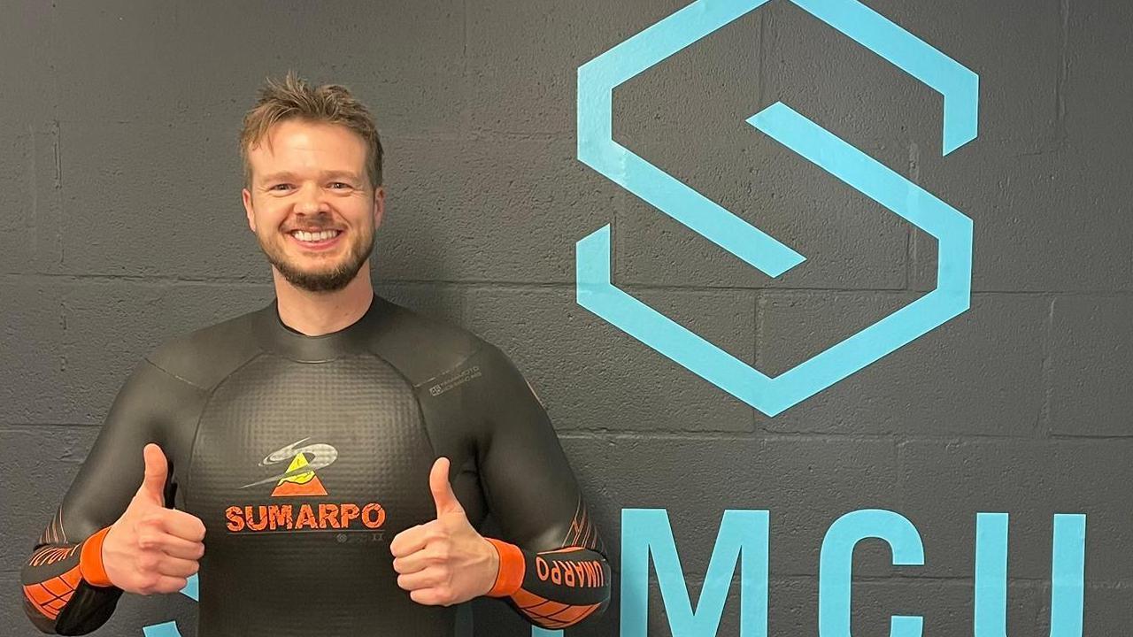 Tony Hopkin in a back wetsuit with his thumbs up. He is smiling.
