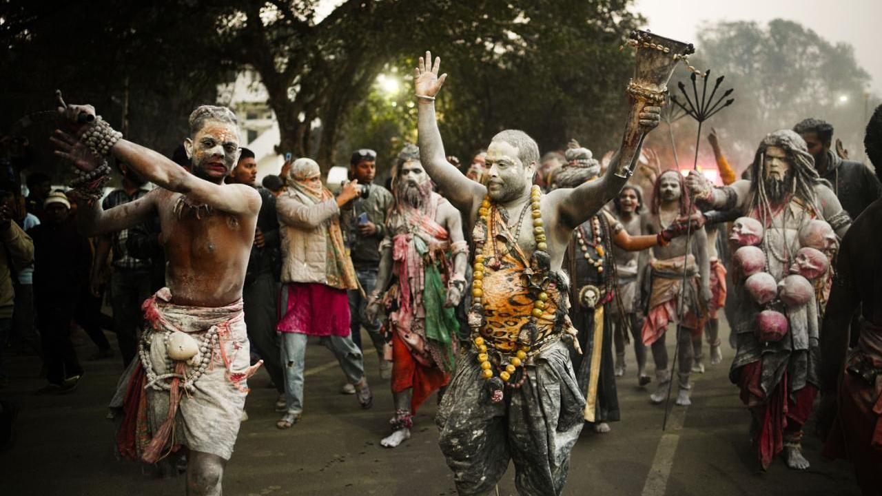 Ash-smeared holy men dancing and entering the festival 