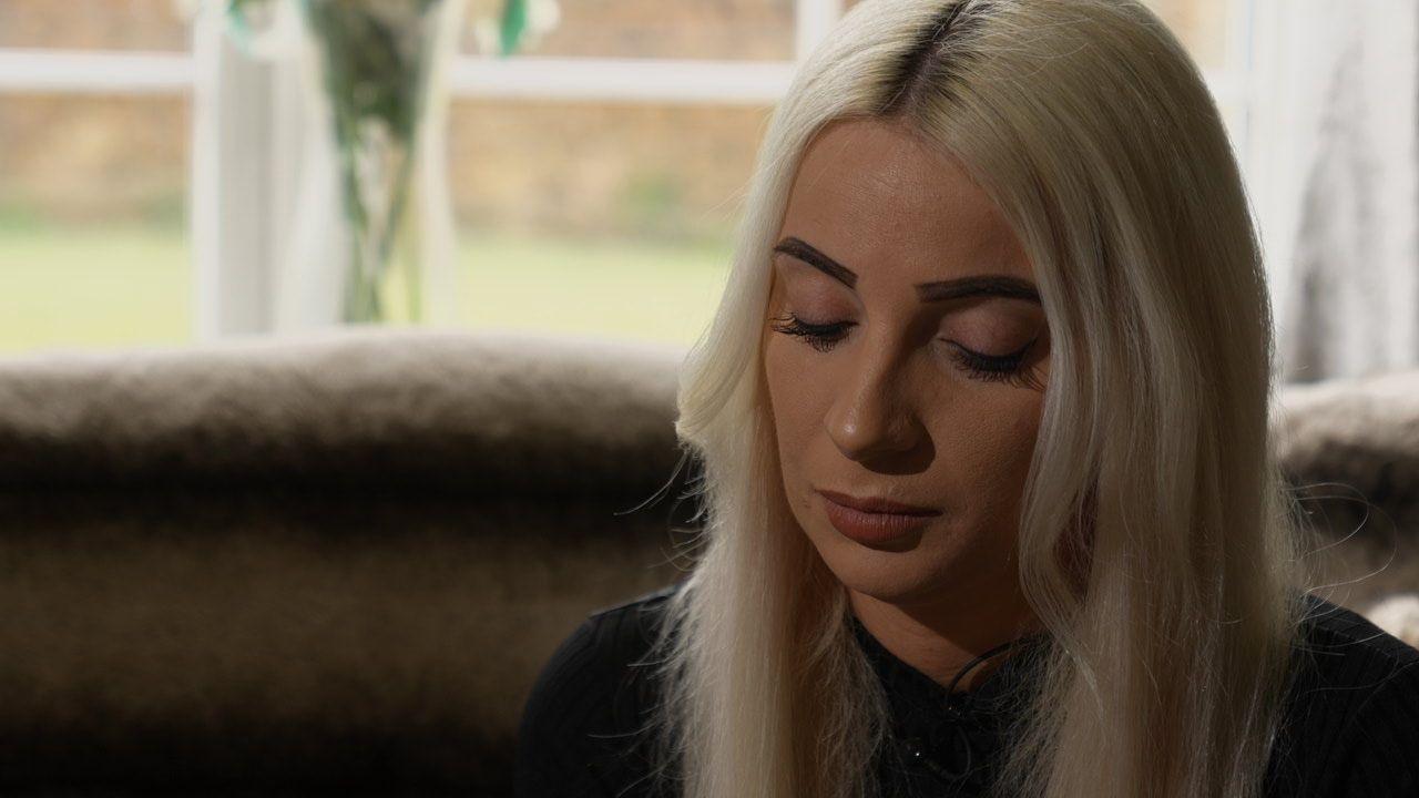 Charlotte Smith has long blonde hair and is wearing a dark top. She is looking down.