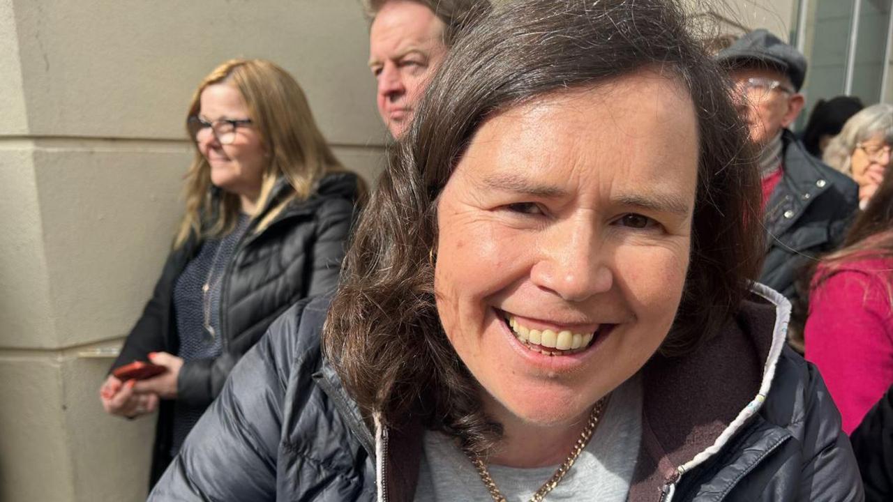 A closeup of a woman smiling with dark hair