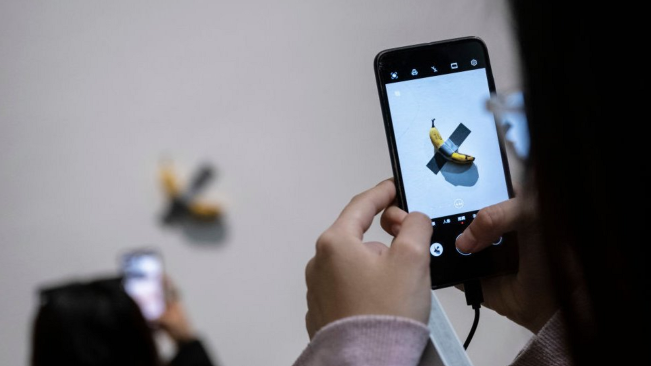 A person taking a photo of the artwork.
