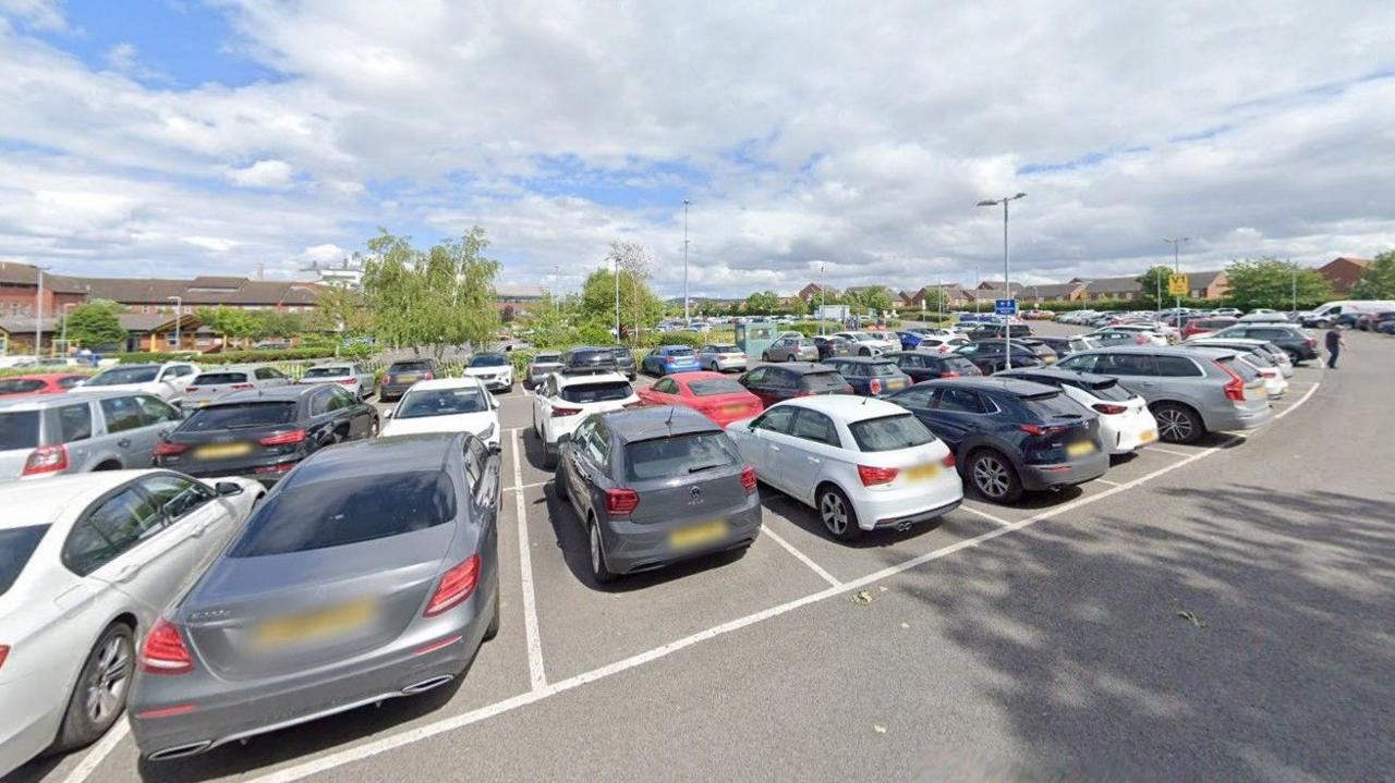 Lots of car parked in hospital parking bays.