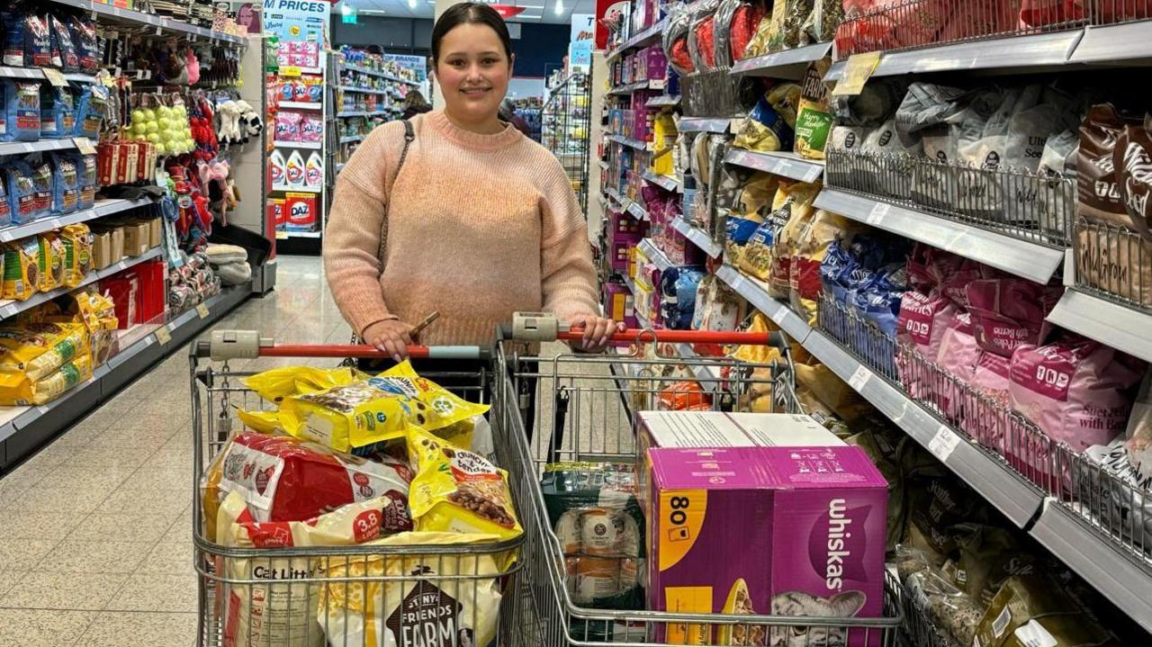 Tyesha Muncaster with two trolley loads of food