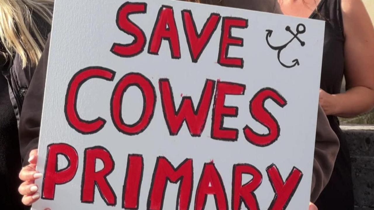 A placard saying 'save Cowes Primary' in red writing on a white background 