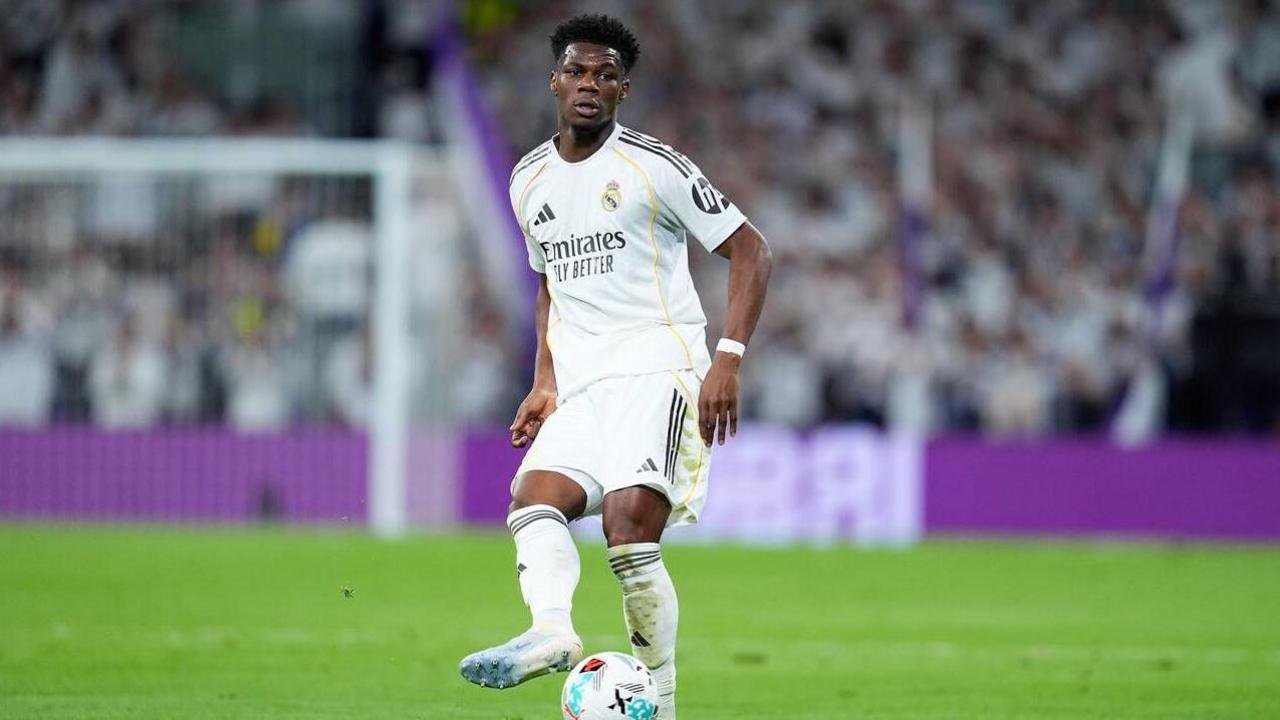 Aurelien Tchouameni passes a ball, he is wearing Real Madrid's iconic white kit