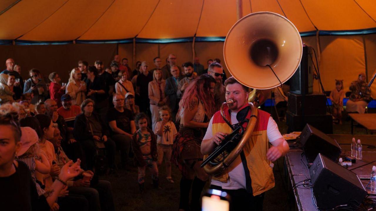 A brass band playing before a crowd