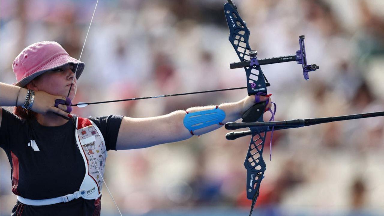 Penny Healey holding a bow and arrow