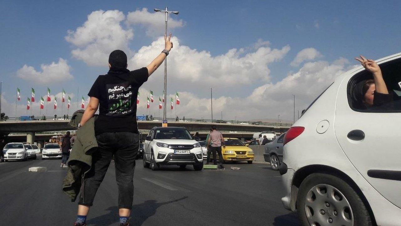 File photo showing a protester wearing a T-shirt saying "We will fight. We will die. We will take back Iran" and gesturing on a highway in Karaj, west of Tehran, on 3 November 2022