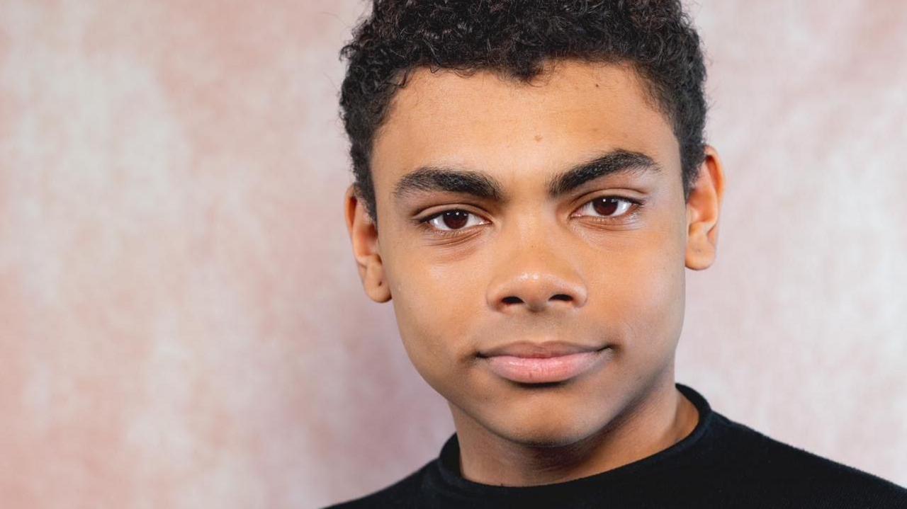 Young man looking at the camera with a neutral background