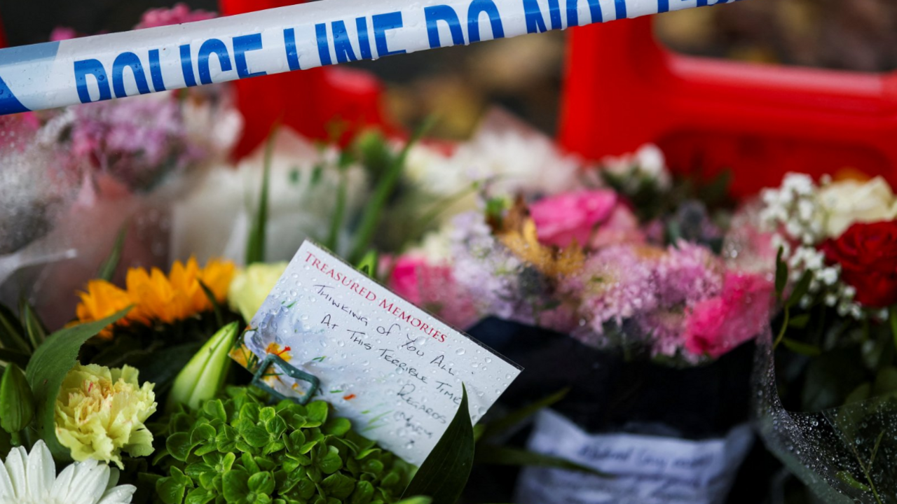 Floral tributes left outside the synagogue, with the image crossed with a section of police cordon