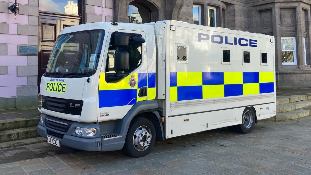 A States of Jersey Police van outside a building with pink bricks.