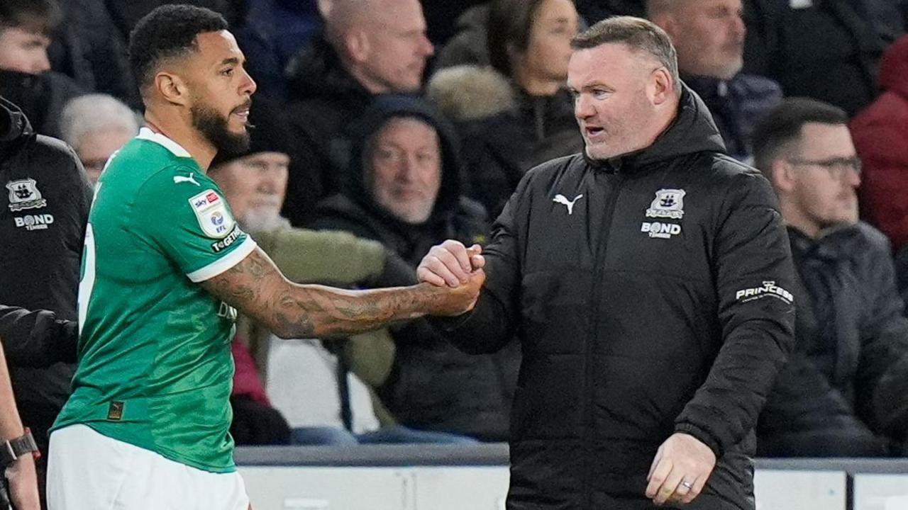 Wayne Rooney shakes hands with Plymouth striker Andre Gray