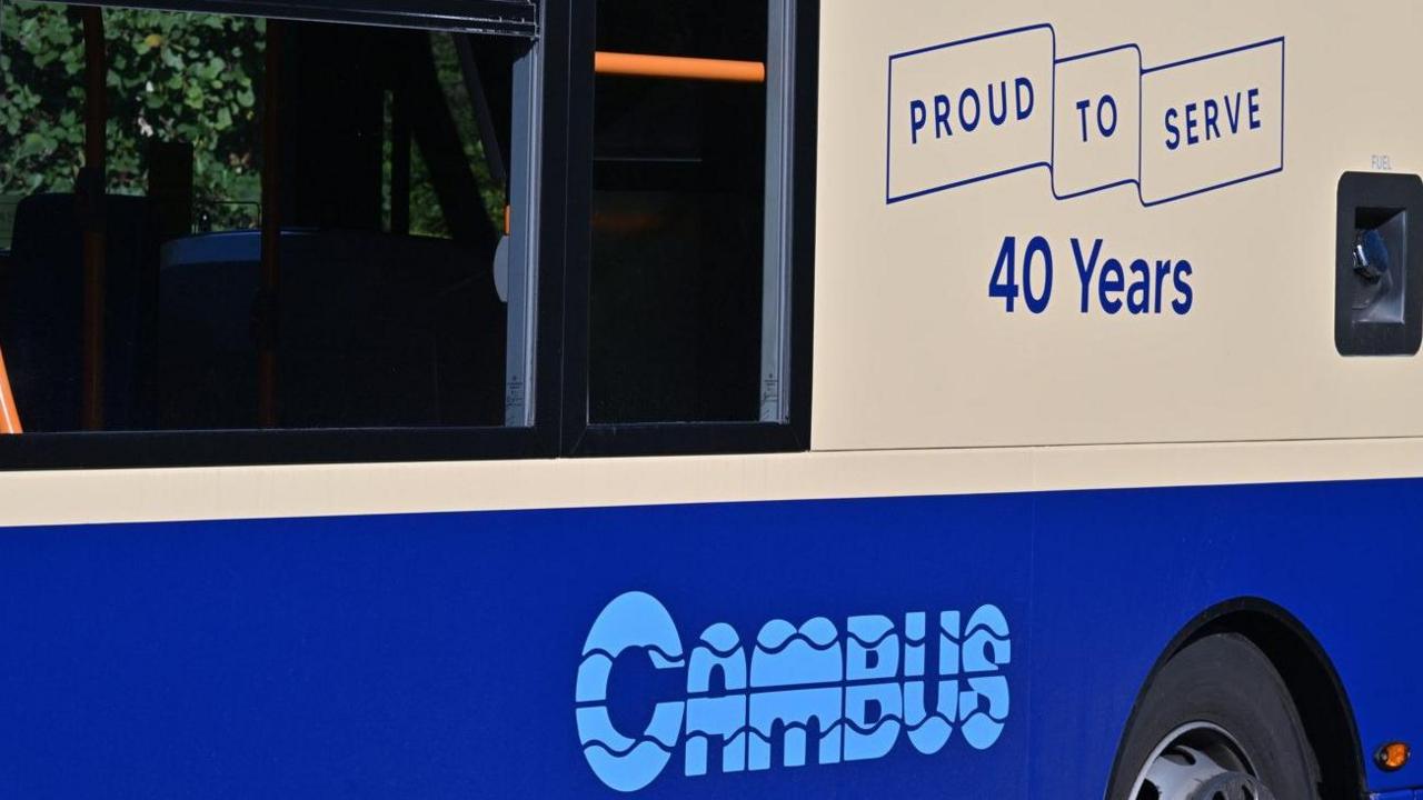 The side of a bus showing the Cambus logo and the phrase "proud to serve 40 years". The bus is blue and cream-coloured