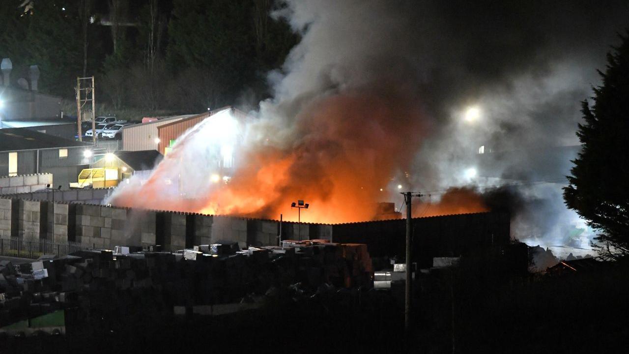 A large blaze within a building being tackled by firefighters