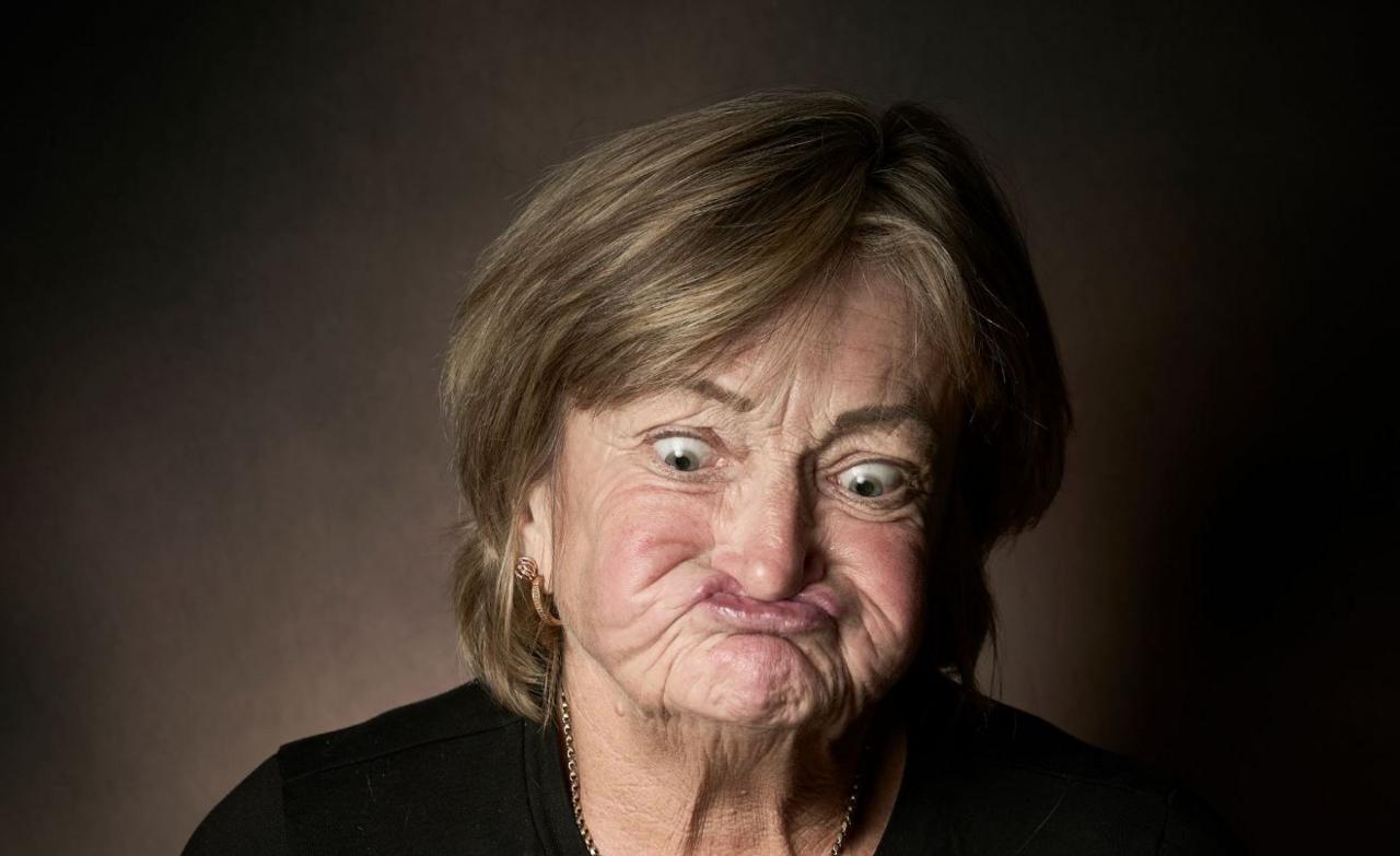 Lynn Proctor has short fair hair and her mouth contorted to tuck under her nose and her eyes looking down.