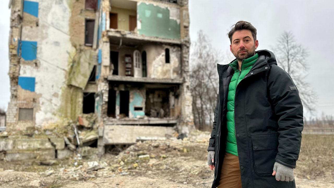 Newsround's Ricky Boleto stands next to a house which has been destroyed in the war in Ukraine