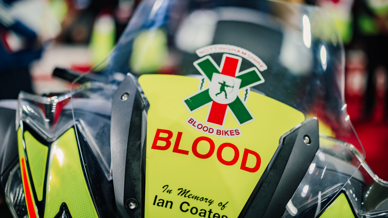 The front of a yellow motorbike with the Nottinghamshire Blood Bikes logo and text which reads "in memory of Ian Coates"