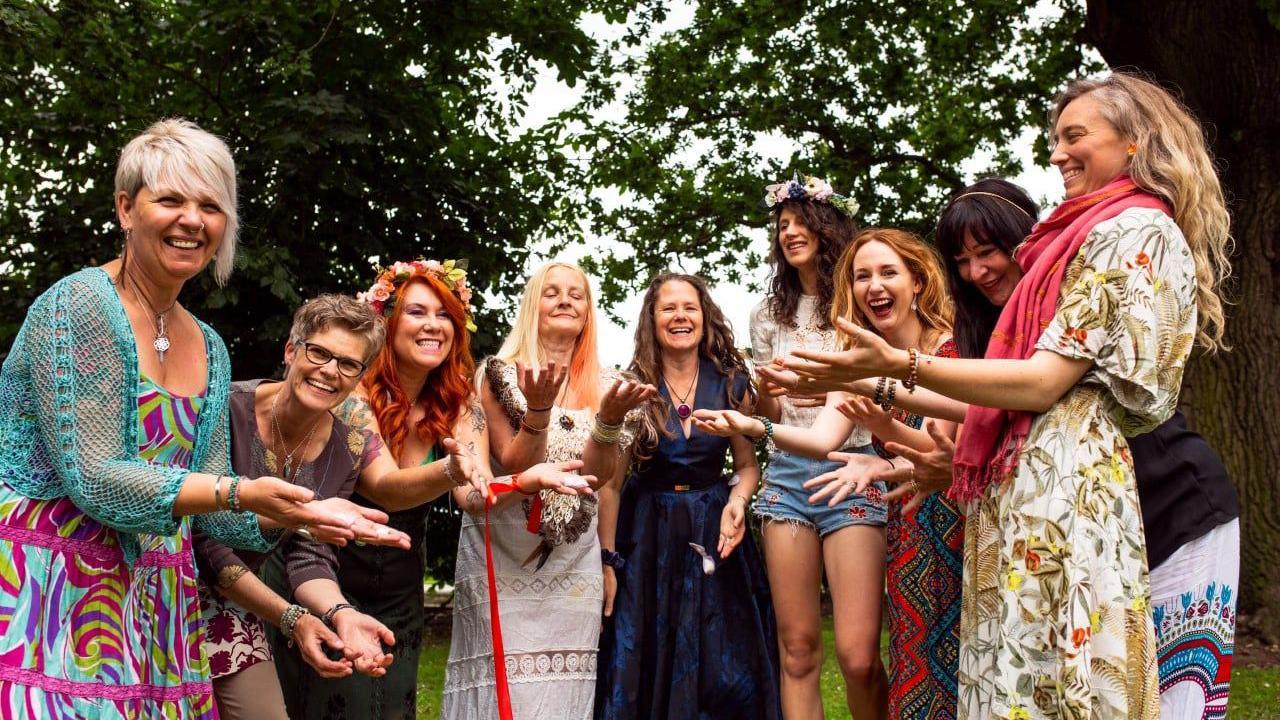 Nine women taking part in a cacao ceremony which combines ancient practices from Aztec or Mayan cultures to aid emotional release. 
  
