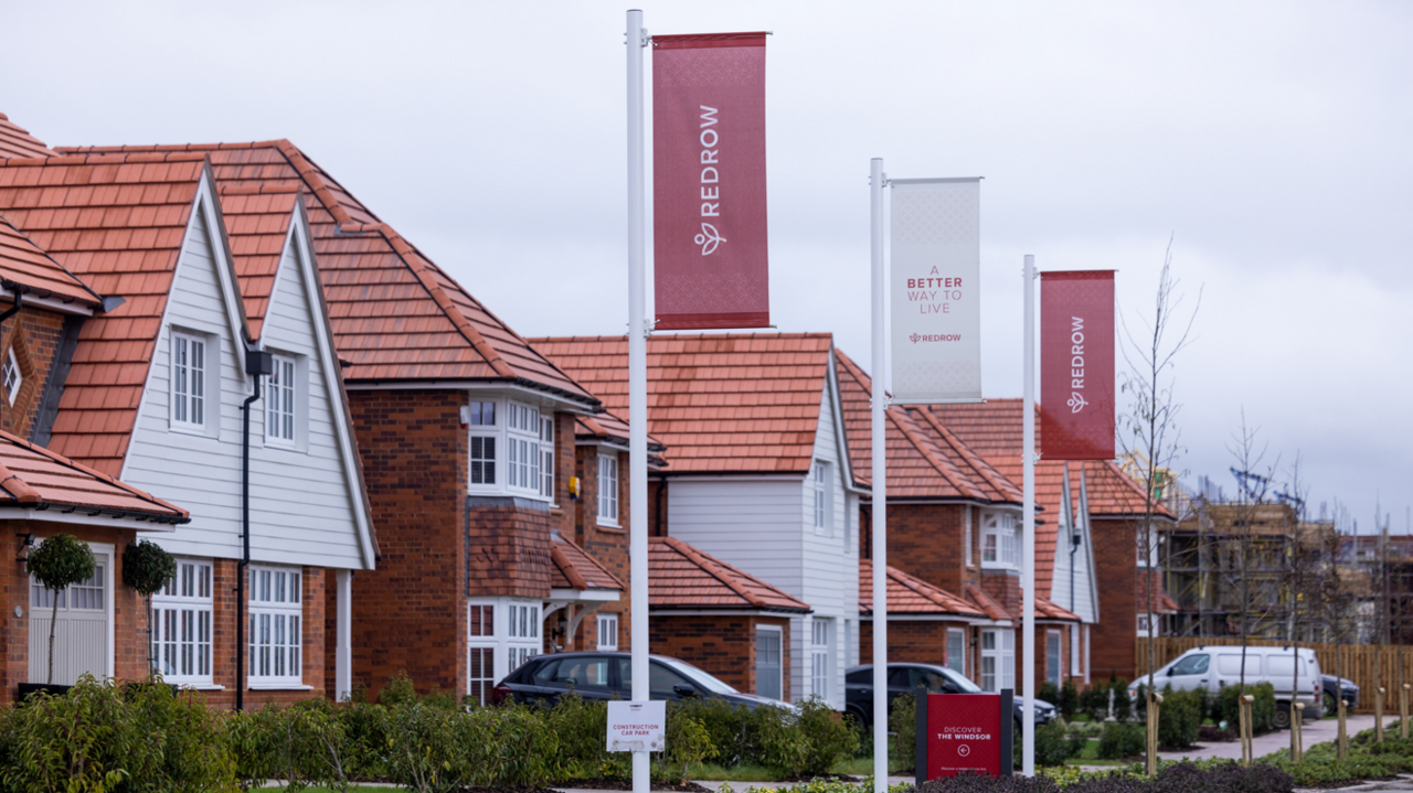 A street of Redrow homes with red flags outside