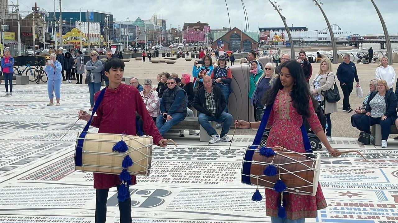 Ahaan and Shriya playing the dhol drum