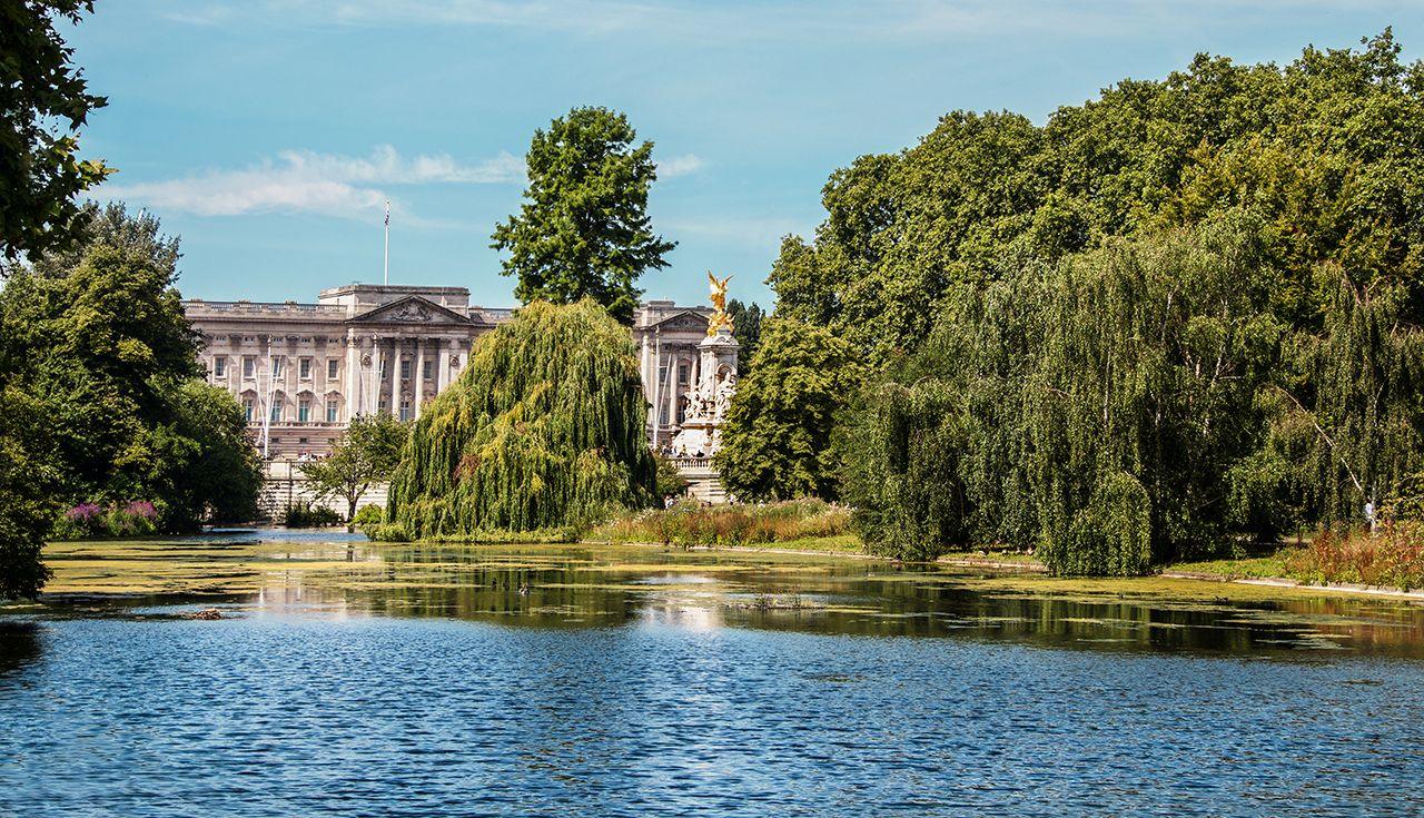 A general view of St James's Park in London, with the pond pictured in front of trees with plenty of leaves and Buckingham Palace and Victoria's Statue visible in the background