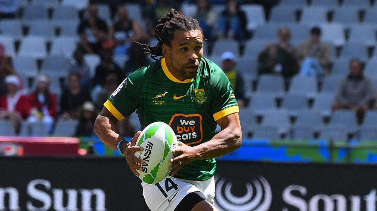 South Africa's Rosko Specman carries the ball forward during a rugby sevens game