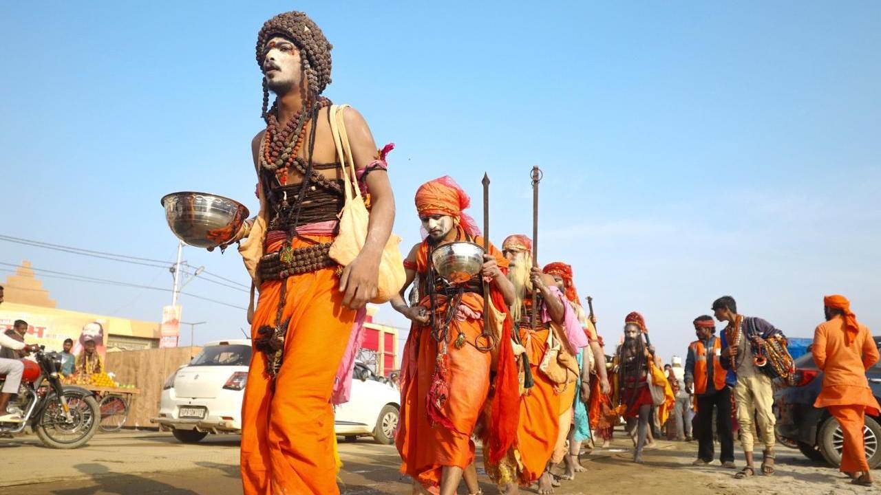 A group of men in saffron clothing walking in the festival grounds