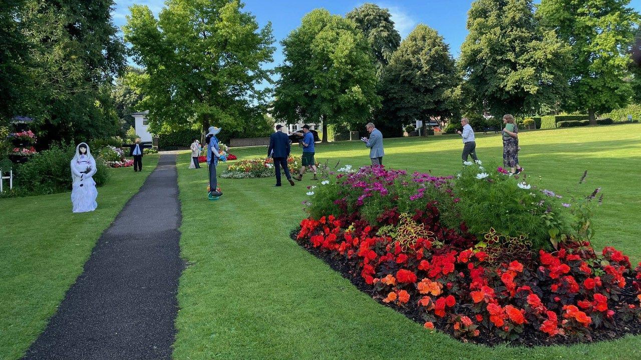 People looking at scarecrows and flower beds in Haywards Heath