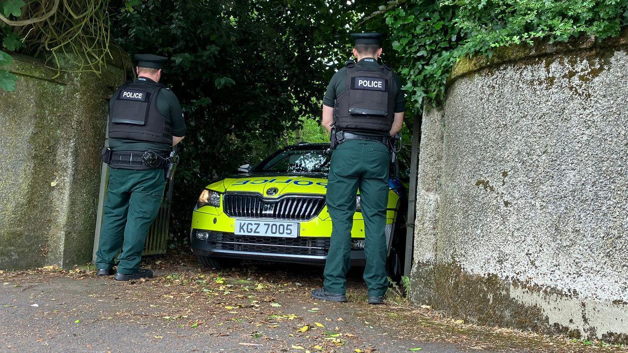 police stand outside the house where the man's body was found