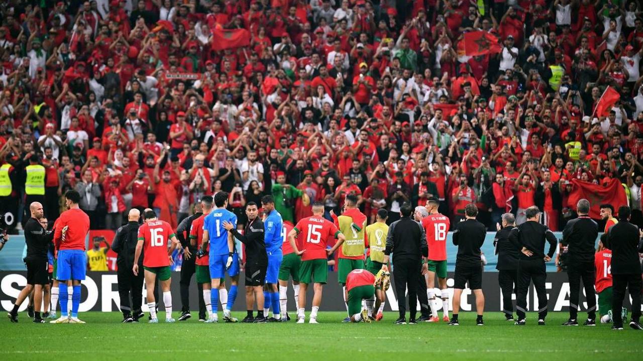 Morocco players stand in front of their fans after being eliminated from the semi finals at Qatar 2022