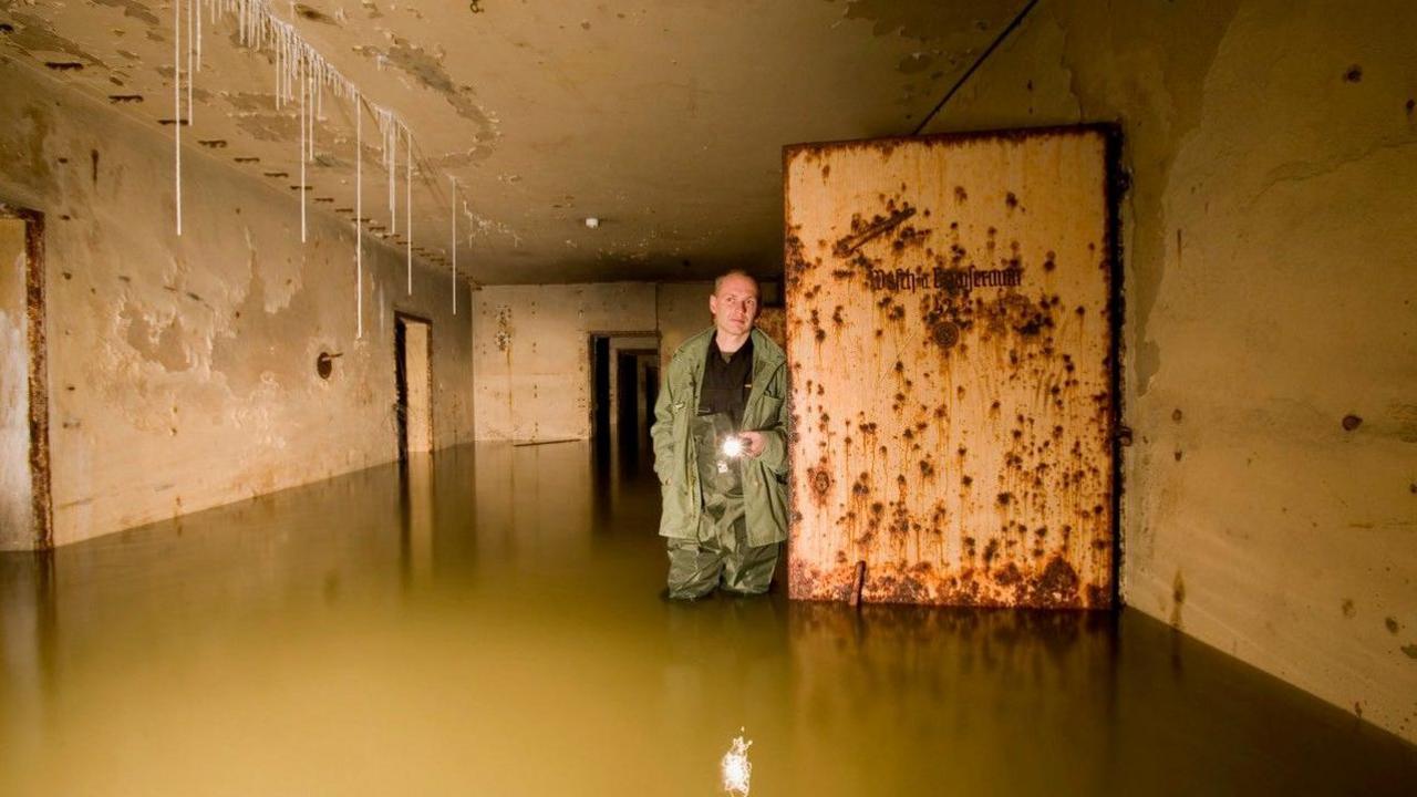 Dietmar Arnold stands with a torch in a flooded Hitler's bunker in 2007