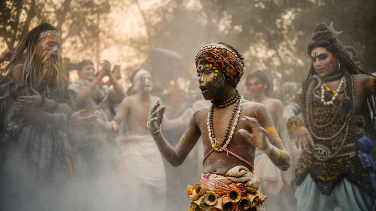 A group of ash-smeared Hindu holy men performing rituals at the Mahakumbh