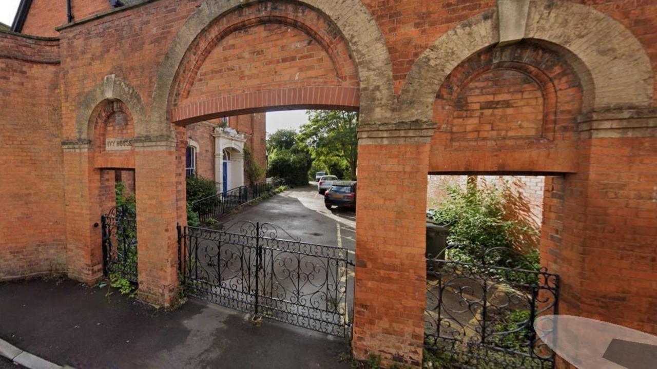 Image shows the same area in the picture above but from a point further back, which shows a red brick archway. 