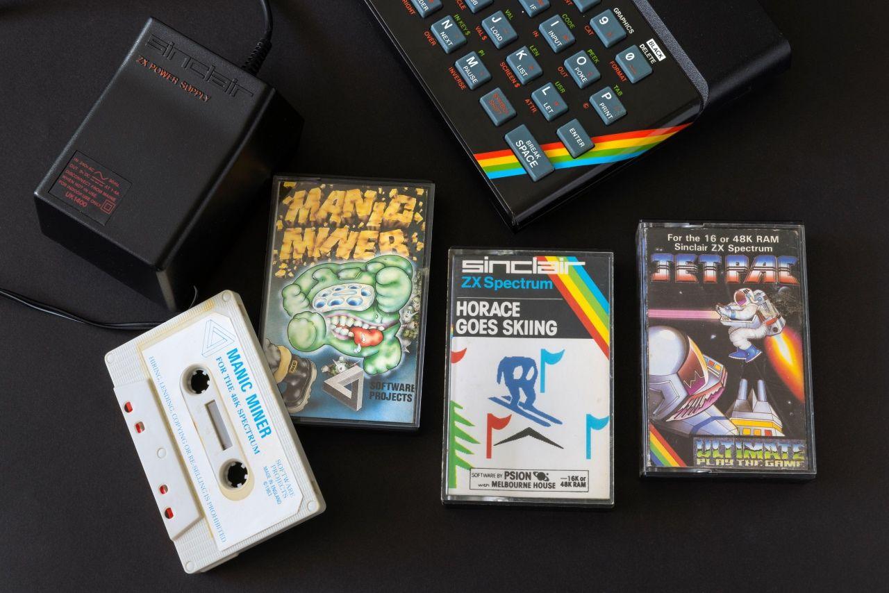 A ZX Spectrum home computer with three games on cassette and a power adaptor. The games are Manic Miner, Horace Goes Skiing and Jetpac