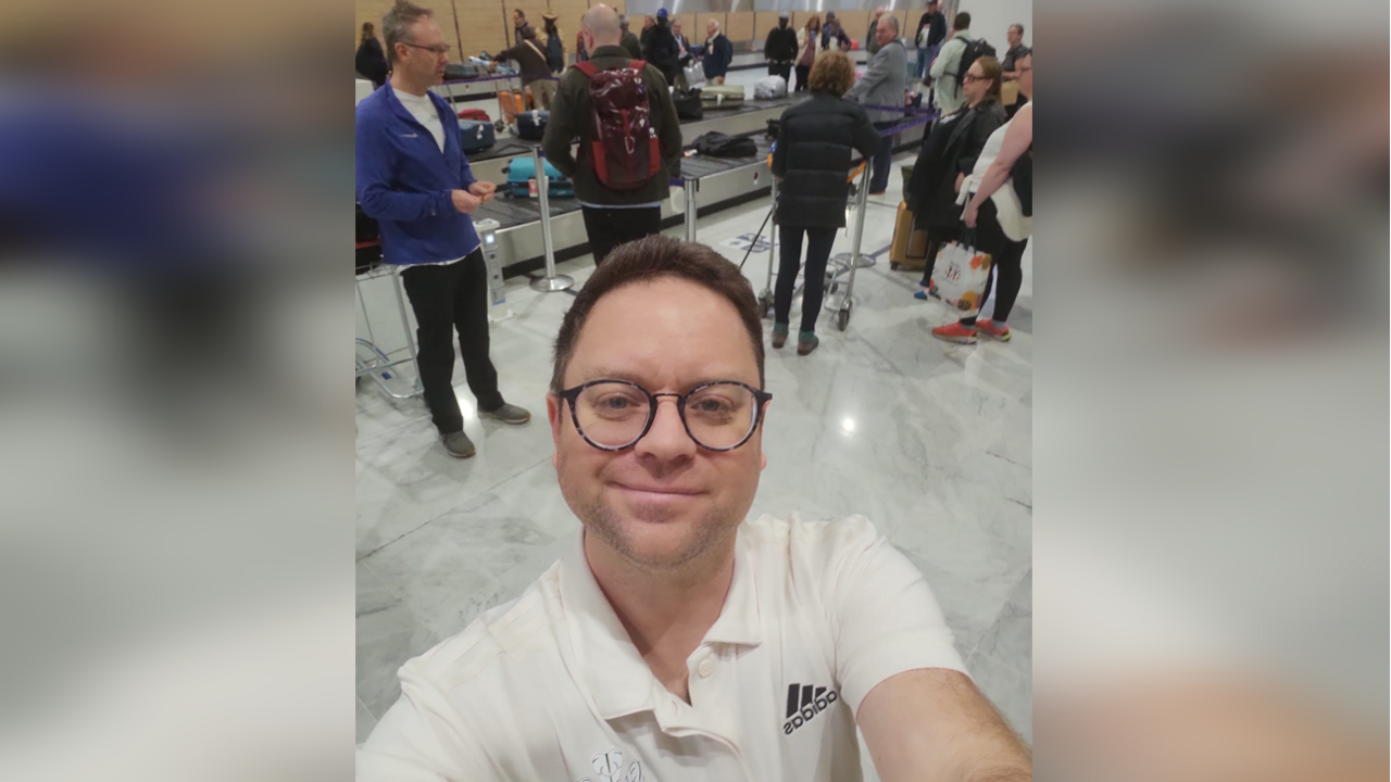 Steve takes a selfie of himself in Paris at a baggage carousel in an airport