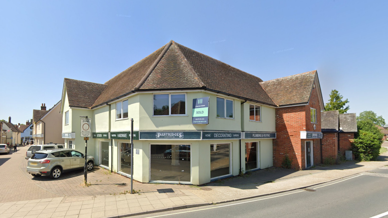 A light green building in High Street, Hadleigh with cars parked nearby.