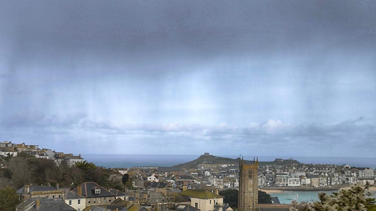 Rain is falling from a big grey cloud over St Ives in Cornwall