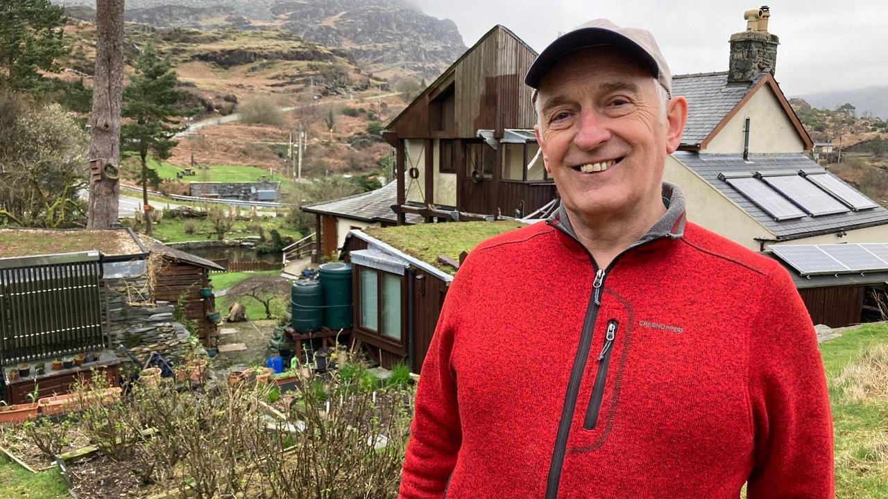 John Whitehead with his guest house behind him