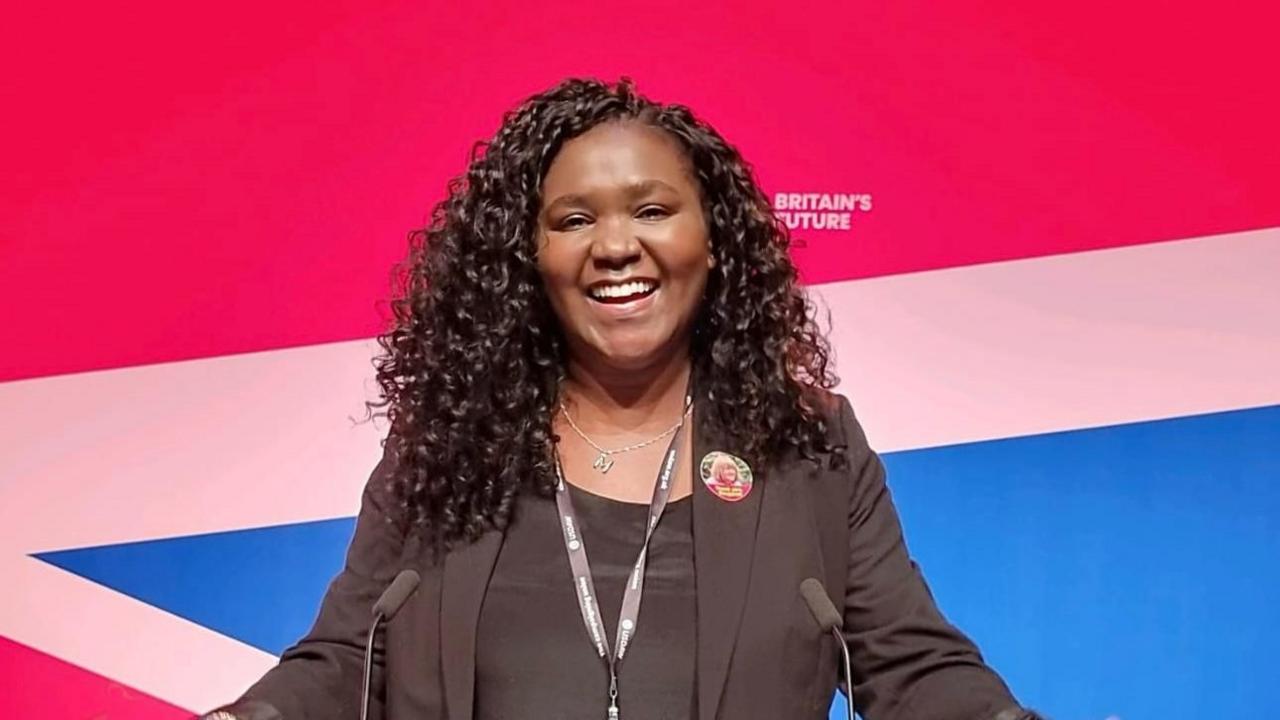 Marianne Kimani standing at a lectern 