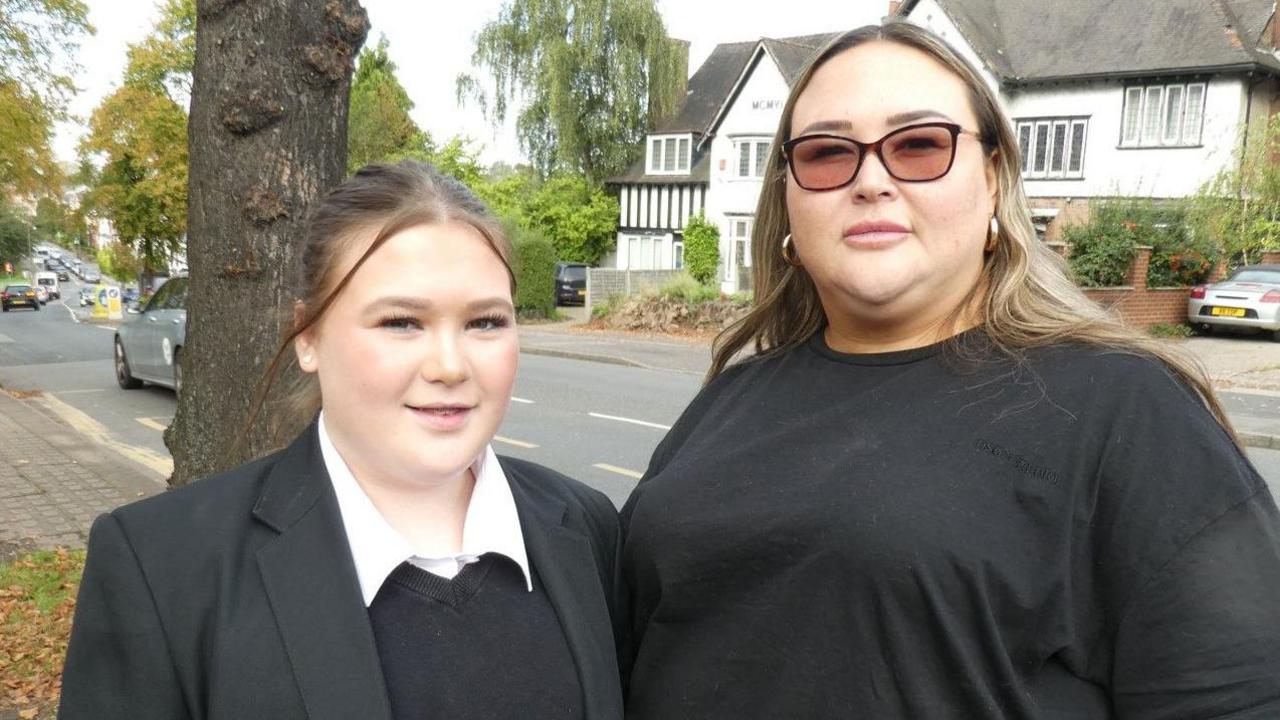 Donna on the right is pictured with daughter Hannah-Louise next to a tree and a road