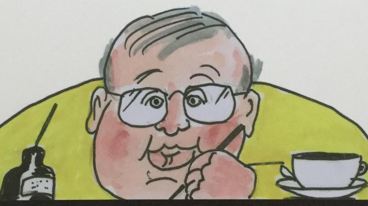 A cartoon self-portrait, showing Phil Woodford drawing with an ink pot on one side an a cup of tea on the other. He has grey hair and is wearing glasses and a yellow jumper.
