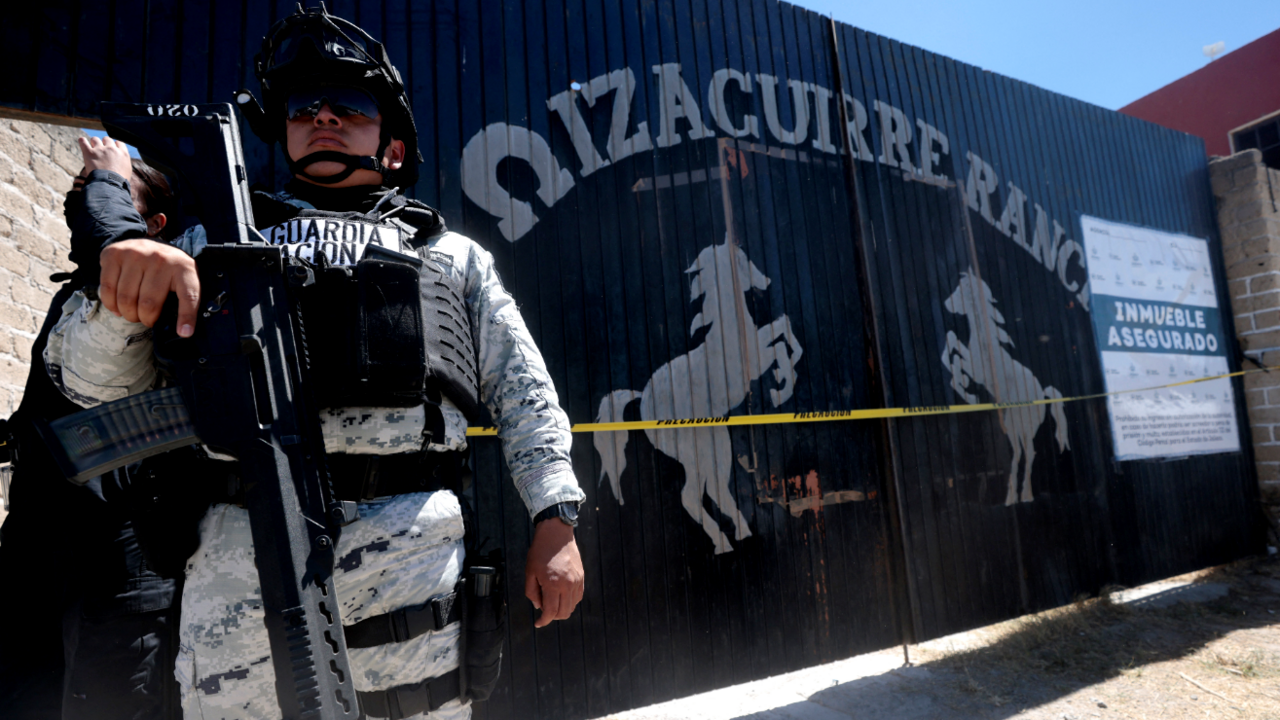 National Guard officers stand guard while members of the collective "Guerreros Buscadores" visit the Izaguirre ranch, where on March 5 they located three human crematory ovens 