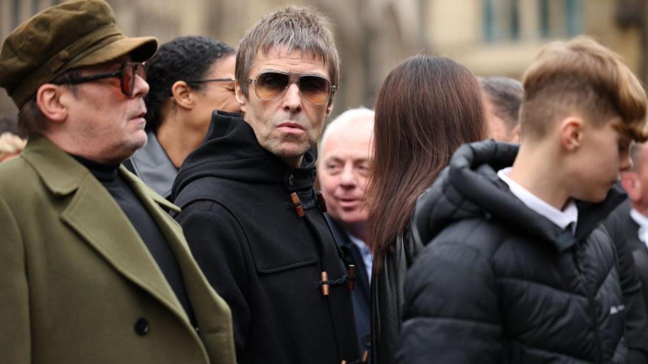 Musicians Gary 'Mani' Mounfield and Liam Gallagher are pictured amongst the crowds at Ricky Hatton's funeral service at Manchester Cathedral