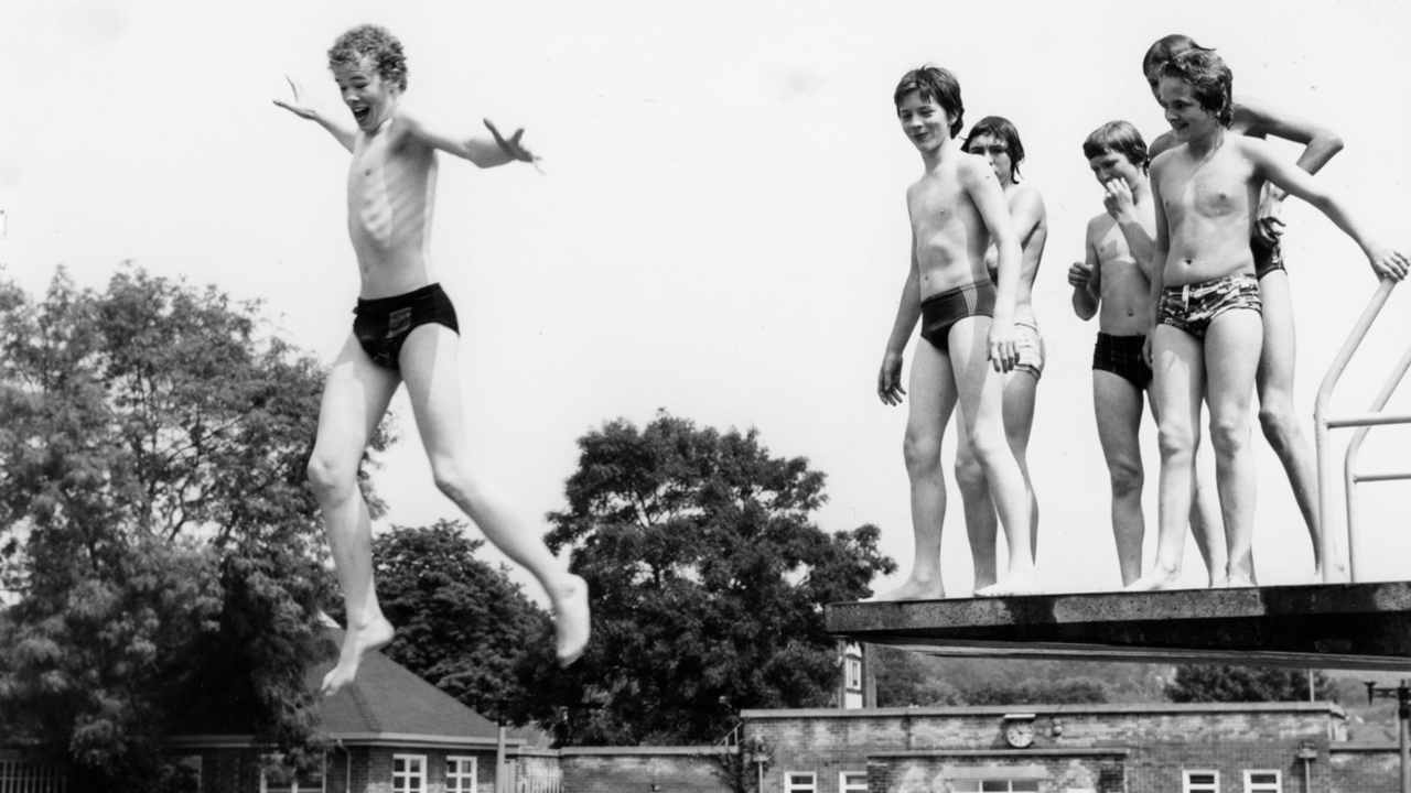 Boys jumping off diving board