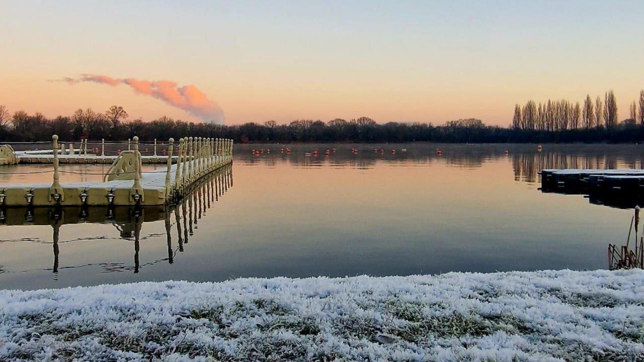 A lake with the grass next to it covered with frost.